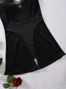 Detail of black sheer mesh bodysuit with lace-up hollow design and rose accessory