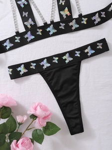 Detailansicht des schwarzen Dessous-Sets mit schillernden Schmetterlingsdrucken und Ketten
