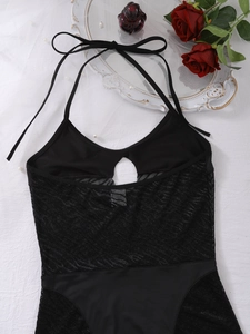 Detailed flat lay of black halter mesh bodysuit with lace patchwork and keyhole cutout