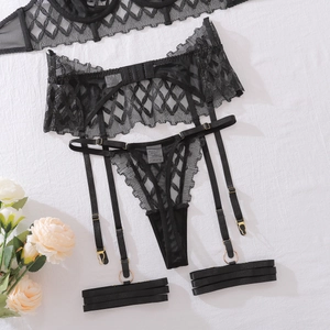 Detail of black lace garter belt with mesh pattern and golden metal buckles