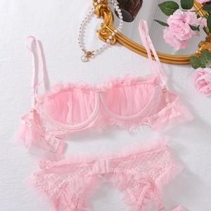 Dettaglio del set di lingerie in pizzo rosa con volant e rete su uno sfondo elegante