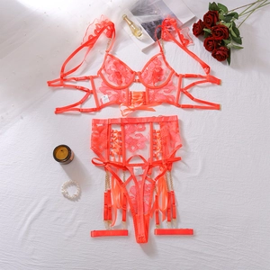 Dettaglio del set di lingerie corallo con ricamo floreale raffinato e nastri di raso