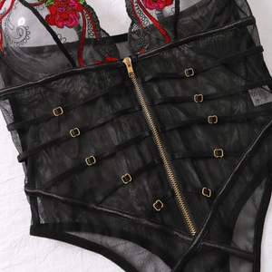 Détail d'un body en résille noire avec broderie florale rouge et fermeture éclair dorée