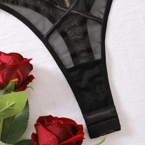 Détail d'un body en maille noire transparente avec bordure en satin et zip