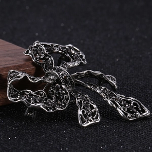 Macro shot of retro gunmetal bow brooch with shimmering black rhinestones detail