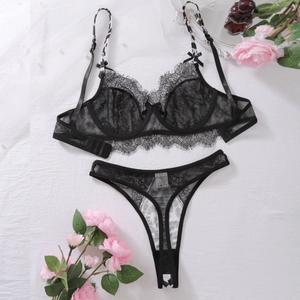 Detailed macro view of black lace lingerie set with leopard print straps and satin bows