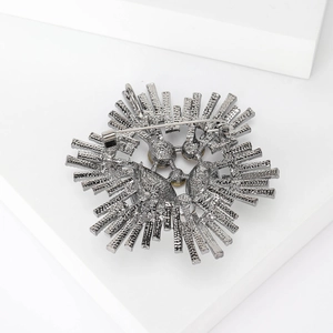 Vintage gunmetal sunburst brooch with textured radial design and secure pin backing