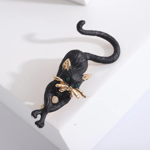 Minimalist black cat brooch in matte alloy with gold details and green gemstone eyes