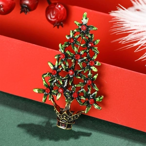 Exquise broche sapin de Noël évidée en émail vert et strass rouges sur un fond festif élégant