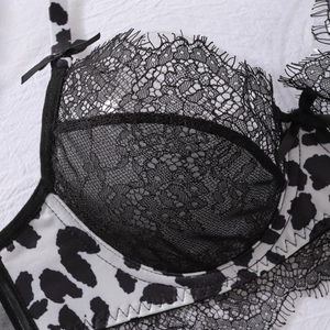 Detail of eyelash lace trim and cow print pattern on lingerie bra with bow accent