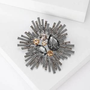 Detailed macro view of sunburst vintage brooch with grey crystals and champagne stones