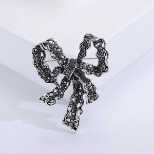 Vintage bowknot brooch featuring black crystals in an antique silver alloy setting