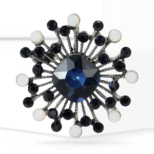 Macro shot of vintage silver brooch with deep blue crystal and white opal beads