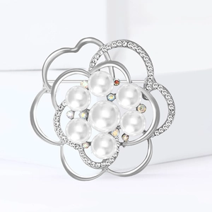 Broche fleur évidée avec perles et cristaux sur fond blanc minimaliste