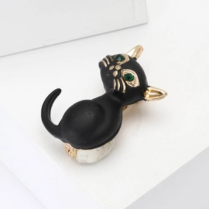 Broche chat noir en émail avec yeux en cristal vert et détails en métal doré