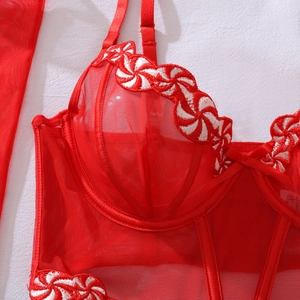 Détail du corset en résille rouge avec broderie de bonbons et armatures de maintien