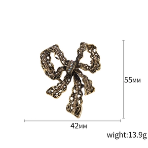 Vintage gold alloy bow brooch with rhinestones and dimensions 55mm by 42mm
