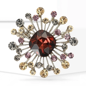 Close-up of vintage radial brooch with deep red gem and sparkling crystal rhinestones