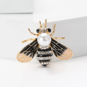 Détail macro de broche abeille en émail avec perle d'imitation et pavé de cristaux