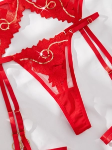 Details von roter Blumenspitze mit Goldpailletten am Dessous-Set und Verstellriemen