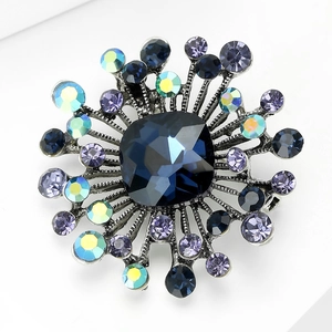 Detailed macro shot of vintage floral brooch with blue crystal and dark alloy finish