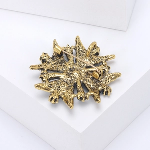 Close-up of vintage gold alloy brooch back with secure pin and pendant loop detail