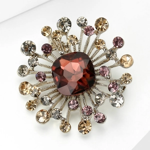 Detailed macro view of a floral brooch featuring a ruby red center stone and rhinestones