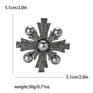 Vue détaillée d'une broche croix vintage avec perles gris foncé et strass brillants