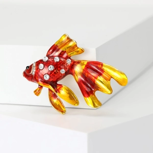 Macro di una spilla a forma di pesce rosso 3D con smalto rosso e strass scintillanti