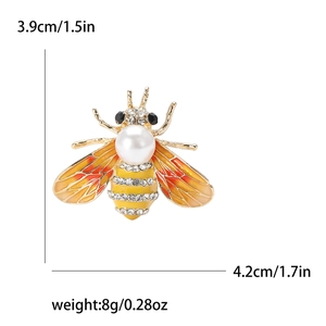 Broche abeille en émail avec perle et strass, dimensions 3.9x4.2cm sur fond blanc