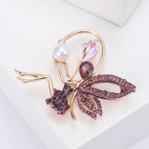 Macro detail of fairy brooch featuring purple rhinestones and white pearl on gold alloy
