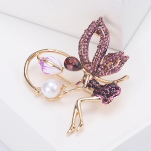 Macro detail of fairy brooch with purple rhinestones and white pearl on white stand