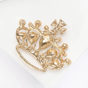 Detail view of the golden crown brooch back showing the secure metal safety pin clasp