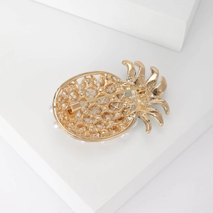 Creative golden pineapple brooch with pearls and intricate lattice design on white background