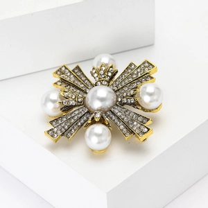 Broche baroque vintage avec perles blanches et strass sur un support doré