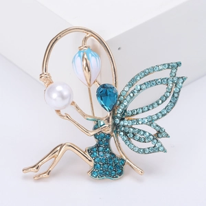 Elegant fairy brooch with sea blue rhinestones, gold plating, and a white pearl accent