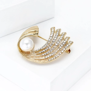 Detalle de un broche vintage bañado en oro con perlas elegantes y diamantes de imitación