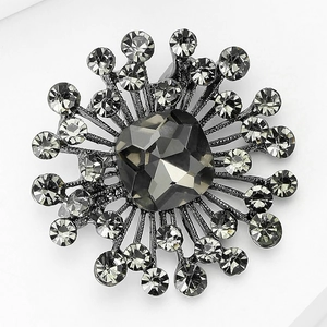 Detailed top view of a retro sunburst brooch with gunmetal plating and grey smoky crystals