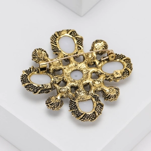 Detail view of the vintage gold brooch back featuring a secure metal pin clasp fastener