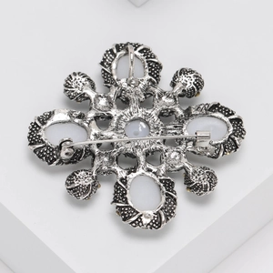 Detail view of vintage brooch back with silver metal texture and safety pin clasp