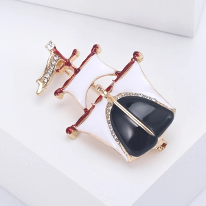 Détails de la broche voilier avec émail noir et blanc et des strass brillants sur métal doré