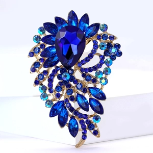 Gros plan détaillé d'une broche en alliage doré avec des cristaux bleu marine et des strass