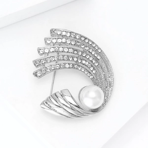 Vista macro detallada de broche plateado con perla blanca y brillantes de strass