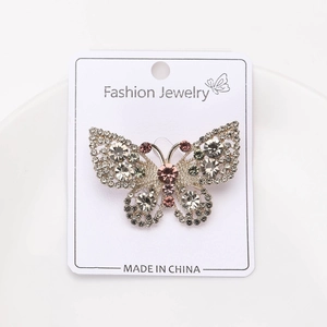 Detail of silver butterfly brooch with pink rhinestones and hollow wing design