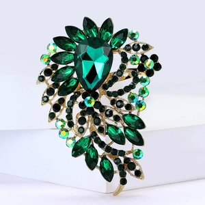 Détail macro d'une broche en alliage avec un grand cristal de verre vert taillé en poire