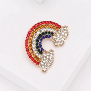 Elegant rainbow brooch with colorful rhinestones and cloud detail on white background