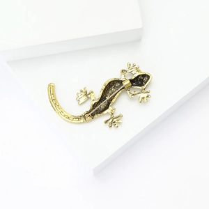 Macro shot of vintage gold alloy lizard brooch detailing back clasp and textured surface