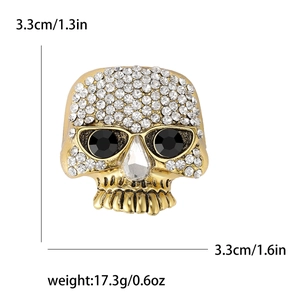 Hip hop style gold skull brooch with sparkling rhinestones and black gemstone eyes