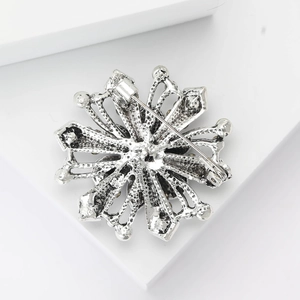 Detailed back view of a silver snowflake brooch featuring a secure rotating safety clasp