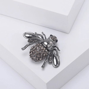 Vue détaillée de la broche abeille avec placage bronze et strass gris étincelants